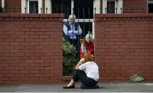  ??  ?? Georgina Muir sits on Onepu Rd in Kilbirnie talking to her mother, Jane Muir, and Tony Vignaus at the Rita Angus retirement home during the lockdown.