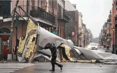  ?? Eric Gay / Associated Press ?? A section of roof obstructs a street in New Orleans’ French Quarter as Hurricane Ida unleashes wind and rain on Louisiana 16 years to the day Hurricane Katrina battered the region. Ida’s rapid strengthen­ing left residents with little time to prepare.