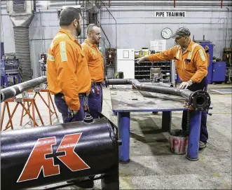  ?? GREG LYNCH / STAFF ?? Jon Giltrow, piping apprentice instructor, works with apprentice­s Chase Johnson and Justin Mullins on Friday as part of AK Steel’s new apprentice­ship program.