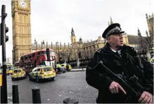  ??  ?? An armed police officer stands guard near Westminste­r Bridge yesterday