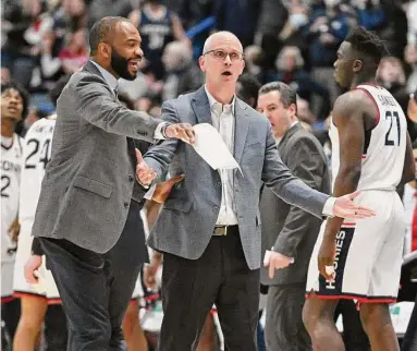  ?? Jessica Hill / Associated Press ?? UConn coach Dan Hurley, center, reacts with associate coach Kimani Young in the first half against St. John’s on Jan. 15.