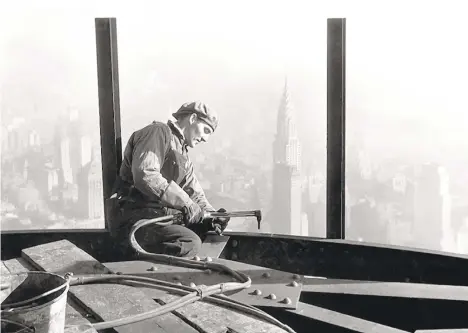  ?? LEWIS HINE/NATIONALAR­CHIVE/NEWSMAKERS ?? Lewis Hine captured this portrait of a constructi­on worker welding steel girders on the Empire State Building in NewYork City around 1930. In the background is the Chrysler Building.