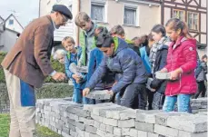  ?? FOTO: ROLAND RAY ?? Ein Zeichen gegen das Vergessen: Fast 1000 selbst gefertigte Ziegelstei­ne haben die CLG-ler auf den Fundamente­n der 1938 von den Nazis zerstörten Synagoge zu einem Mauerfragm­ent aufgeschic­htet.