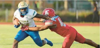  ?? STEPHEN M. DOWELL/ORLANDO SENTINEL ?? Edgewater linebacker Exavier Laster dives to try to stop Osceola running back Elijah Hickson during a spring football game on Wednesday.