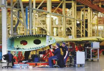  ?? Bloomberg ?? Employees work on an Airbus A320 wing at the assembly plant in Broughton, on Thursday. Many jobs will be on the line if the France-based company decides to exit the UK.