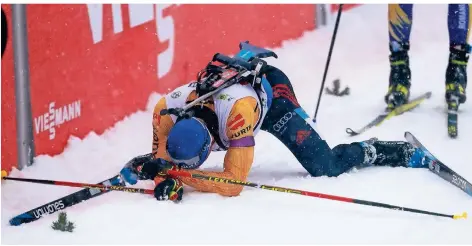  ?? FOTO: DARKO BANDIC/AP/DPA ?? Erik Lesser liegt nach seinem Einsatz in der Mixed-Staffel enttäuscht und erschöpft im Ziel.