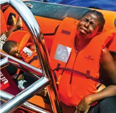  ??  ?? Overcome: A mother on board the rescue boat