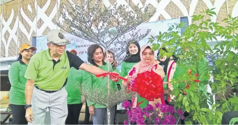  ??  ?? Abang Wahap helps Juma’ani as she cuts a ribbon to launch the programme. At fourth left is Sabati deputy president Datin Amar Doreen Mayang, and at sixth left is Fatimah.