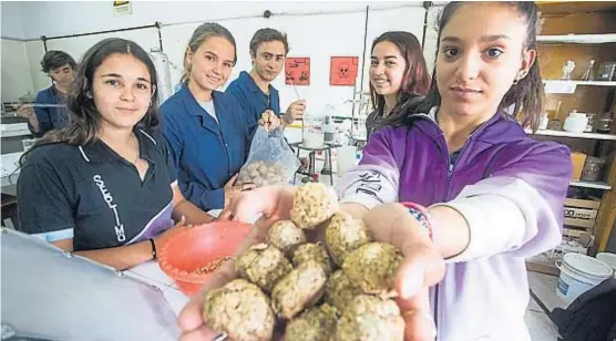  ?? (LA VOZ) ?? Saber hacer. Los alumnos, en el laboratori­o del Ipet Gustavo Riemann, de Villa Rumipal, con el producto que crearon para calefaccio­nar viviendas.