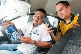  ??  ?? Gan showing Faisal Shafie, manager of tng digital (Urban Mobility) how he would educate passengers about using the touch ‘n Go ewallet.