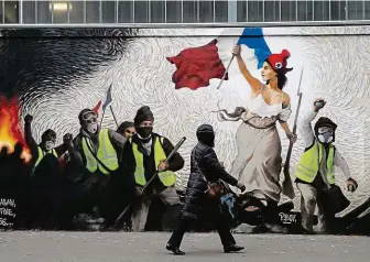  ?? FOTO REUTERS ?? Žluté vesty, vpřed! velí nespokojen­ým Francouzům na fresce v ulicích Paříže Mariana, symbol revoluce