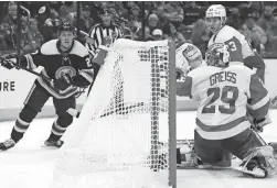  ?? PAUL VERNON/AP ?? Blue Jackets defenseman Adam Boqvist, left, watches his goal against Red Wings goalie Thomas Greiss, center, and defenseman Moritz Seider Monday in Columbus, Ohio.