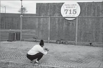  ?? JOHN BAZEMORE/AP PHOTO ?? Krystal Dixon takes a photo in front of Hank Aaron’s home run wall, left from when Atlanta’s Fulton County Stadium was demolished, where Aaron hit his 715th home run on April 8, 1974 to break the career home run record held by Babe Ruth.