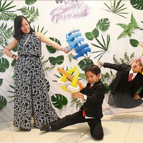  ?? — FAIHAn GHAnI/The Star ?? Family fun: eugenie nair yee yeng Wei, six, (right) poses alongside Mason Tan, 7 (middle) and his mother Kuan Lih yee at the photo booth at the WOW! Fiesta.