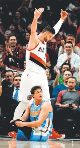  ??  ?? Trail Blazers center Jusuf Nurkic, formerly of the Nuggets, urges the Portland crowd to cheer louder after he scored and drew a foul against Denver forward Danilo Gallinari during the first half of Tuesday’s game. Portland won 122-113. Steve Dykes, The Associated Press