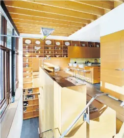  ?? Tomarban ?? The breakfast bar divides the space yet opens up to the sitting area and the expanse of windows with views to the owners’ beloved garden beyond.