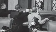  ??  ?? Law enforcemen­t officers point their guns at a door that was vandalized in the House Chamber during a joint session of Congress.