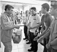  ??  ?? Rayong (third right) joins local government officials to distribute Ramadan goodies and ‘bubur lambuk’ to the locals.