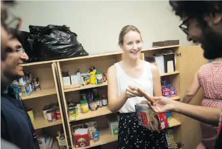  ?? DAX MELMER ?? Jenna Wright, a volunteer at the Campus Foodbank, helps students select items at the food bank at Canterbury College on Tuesday.