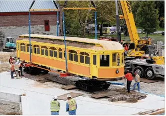  ?? LISA POWELL / STAFF ?? A fully restored 1903 interurban car was moved by crane Thursday into the Carillon Historical Park Heritage Center of Regional Leadership currently under constructi­on. The car has been placed so it will be inside a new, reimagined Culp’s Cafe that will open next summer.