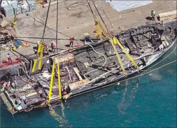  ?? Brian van der Brug Los Angeles Times ?? THE DIVE BOAT Conception is brought to the surface off Santa Cruz Island days after a f ire killed 34 people on Sept. 2, 2019. Early detection of the blaze could have saved lives, according to a federal probe.