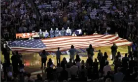  ?? JOHN RAOUX - THE ASSOCIATED PRESS ?? First responders hold a flag on the court as the national anthem is played during a tribute to the victims of the Pulse nightclub shooting prior to an NBA basketball game between the Orlando Magic and the Miami Heat, Wednesday in Orlando, Fla.