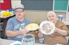  ??  ?? Meadowview Developmen­t Associatio­n president Joe Benjamin and associatio­n member Josie Justason of Meadowview show some of the baked goods for sale at a benefit for the Meadowview Community Centre on Nov. 5.