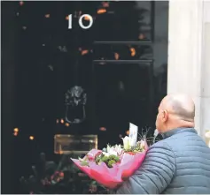  ?? — Reuters photo ?? A man delivers a bouquet of flowers for May in Downing Street, London.