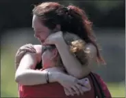  ?? ANDREW NELLES/THE TENNESSEAN ?? Kaitlyn Adams, a member of the Burnette Chapel Church of Christ, hugs another church member at the scene after a deadly shooting at the church on Sunday in Antioch, Tenn.