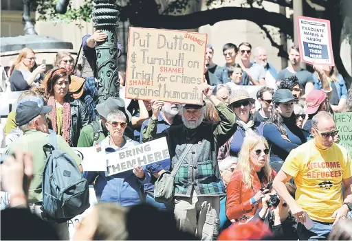  ?? — Gambar Reuters ?? BELAS KASIHAN: Penunjuk perasaan membawa sepanduk dan kain rentang ketika mengadakan demonstras­i protes hak pelarian di tengah Melbourne, semalam.