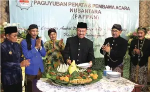  ?? RETNO DYAH/JAWA POS ?? HARI JADI: Ki Sukardji (tengah) memotong tumpeng ulang tahun Pappan pada Senin (14/5).