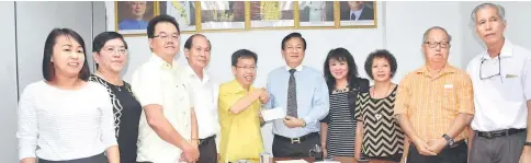  ??  ?? Dr Sim (fifth left) handing over the cheque to the management committee of Kuching Chung Hua Primary Schools No.1 to 6 chairman Wong Tiong Hook (fifth right) as others look on.