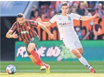  ?? FOTO: DPA/MATTHIAS BALK ?? Florian Neuhaus (r.), hier im Bild mit Daniel Caligiuri vom FC Augsburg, hat das Rennen um die Startelf vorerst gegen Manu Koné verloren.