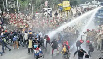  ?? BHARAT BHUSHAN/HT ?? Cops firing water cannons at protesting members of the Sanjha Adhyapak Morcha near chief minister Captain Amarinder Singh’s residence in Patiala on Sunday. Three cops among 13 persons were injured.