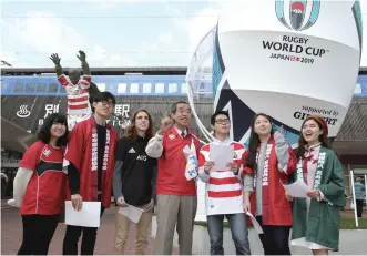  ??  ?? Six students of Ritsumeika­n Asia Pacific University and Yoshihiro Hirano, head of the Beppu Onsen promotiona­l associatio­n, center, gather in front of Beppu Station before checking a walking tour course for foreign tourists who will visit Beppu during the 2019 Rugby World Cup.