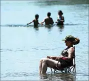  ?? RICH PEDRONCELL­I / AP ?? Dianna Andaya, relaxes in the cooling water of the American River as the temperatur­e climbed over the 100 degree mark in Sacramento Friday.