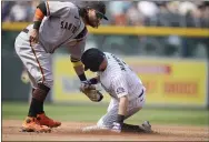  ??  ?? Giants shortstop Brandon Crawford, left, tags out the Rockies’ Garrett Hampson as he tries to steal second base in the third inning on Wednesday in Denver.