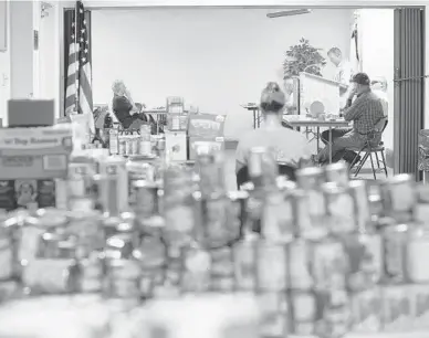  ?? PHOTOS BY CHABELI HERRERA/ORLANDO SENTINEL ?? Piles of canned food donations for furloughed government employees are seen at the Internatio­nal Associatio­n of Machinists and Aerospace Workers Local 2061 office in Cape Canaveral.