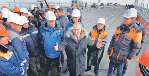  ??  ?? El Presidente ruso Vladimir Putin conversa con obreros durante visita a obras de puente de Crimea, en el estrecho de Kerch, en 2018.