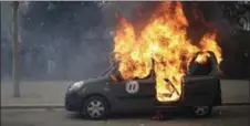  ??  ?? A burning command car belonging to France’s anti-terrorist squad goes up in smoke after being torched by anti-government demonstrat­ors.