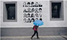  ?? AP 2018 ?? A woman walks past a wall painted with portraits of prisoners of the Basque separatist group ETA, in Hernani, Spain. The U.S. is poised to remove the group from a blacklist.