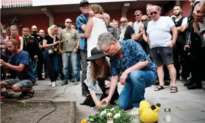  ??  ?? People leave flowers and candles during a memorial service in August for Eric Torell. Photograph: Stina Stjernkvis­t/AFP/Getty Images