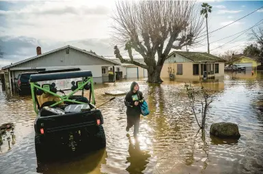  ?? NOAH BERGER/AP ?? Brenda Ortega salvages items Jan. 10 from her flooded home in Merced, Calif., after the state was slammed by storms.