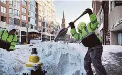  ??  ?? PEKERJA membersihk­an salji tebal di sebatang jalan raya di Boston, Massachuse­tts kelmarin. - Agensi