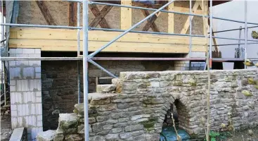 ??  ?? Alte Fachwerkba­lken wurden bewahrt. Neue, wo erforderli­ch, ergänzt. Die Naturstein­mauer ist ein Neubau aus abgebroche­nem Material