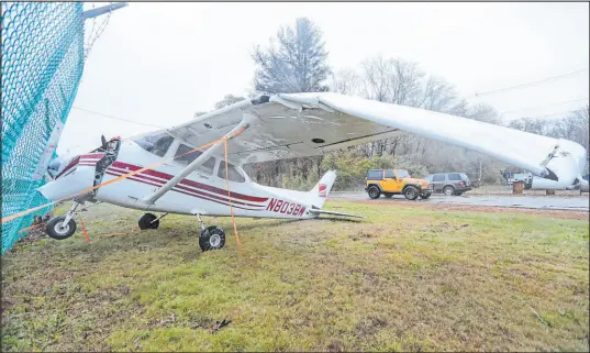  ?? Peter Pereira The Associated Press ?? A small airplane finds itself on the wrong side after high winds lifted it over the airport fence Wednesday in New Bedford, Mass.