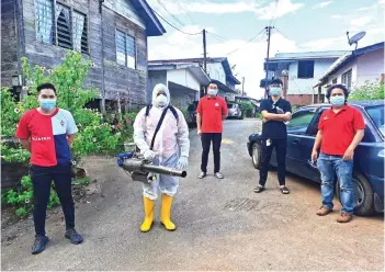  ??  ?? Ting (centre) with his team carrying out disinfecti­on works at Kampung Quop.