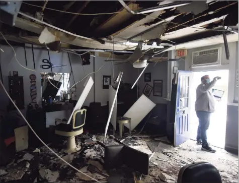  ?? Tyler Sizemore / Hearst Connecticu­t Media ?? Insurance adjuster Elliot Krass takes photos of the fire damage to Belltown Barbers in Stamford on Wednesday. A fire on Sept. 25 caused significan­t damage to Belltown Barbers and the adjoining business, Sandra’s Mexican Food & Taqueria.