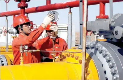  ?? WANG BO / XINHUA ?? Workers replace a pressure meter at the natural gas pipeline of China National Petroleum Corp in the Qaidam Basin in Qinghai province.