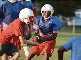  ?? Jerry Baker / For the Chronicle ?? Tomball junior quarterbac­k Tybo Taylor works a handoff to sophomore running back Ryan Herrera last week.